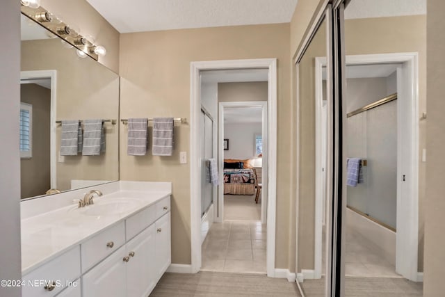 bathroom with vanity, tile patterned flooring, and shower / bath combination with glass door