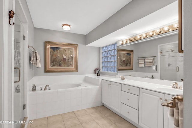 bathroom featuring a bath, a shower stall, a sink, and tile patterned floors