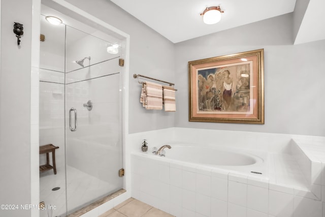 bathroom with a shower stall, a bath, and tile patterned floors