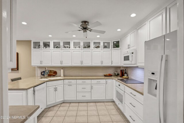 kitchen with glass insert cabinets, white appliances, white cabinetry, and light countertops