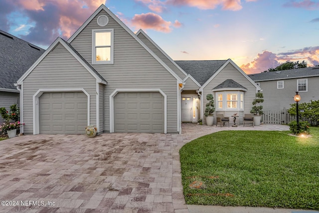 traditional home with fence, decorative driveway, and a front yard