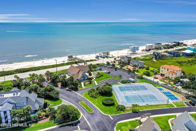 drone / aerial view featuring a water view, a residential view, and a view of the beach