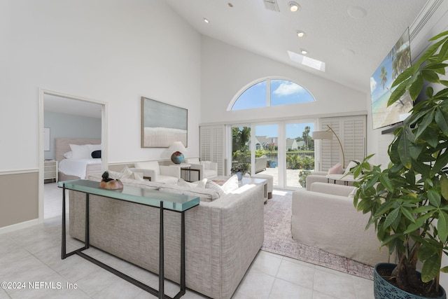 living room with light tile patterned floors and high vaulted ceiling