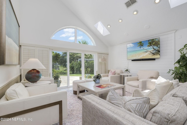 living room featuring a skylight and high vaulted ceiling