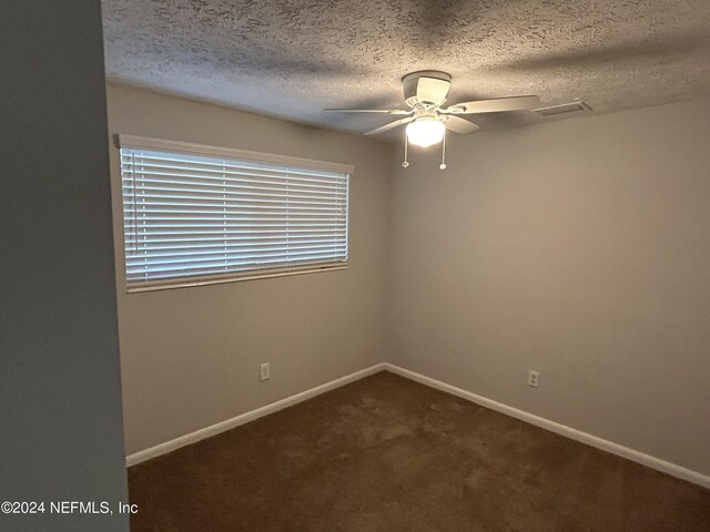 carpeted spare room featuring a textured ceiling and ceiling fan