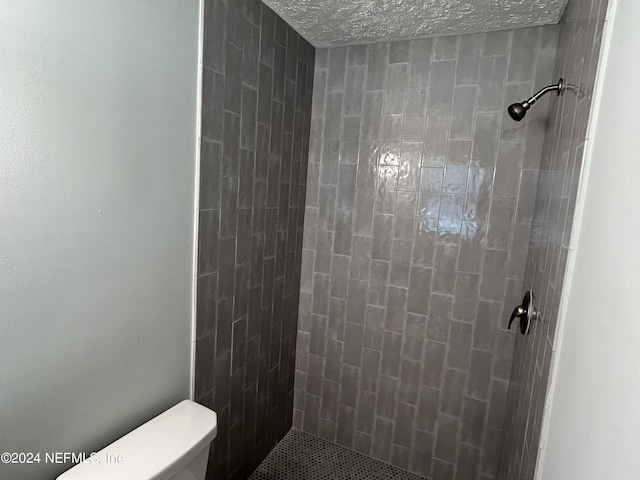 bathroom with toilet and tiled shower