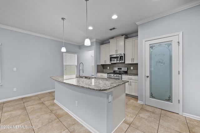 kitchen featuring sink, decorative light fixtures, ornamental molding, an island with sink, and stainless steel appliances