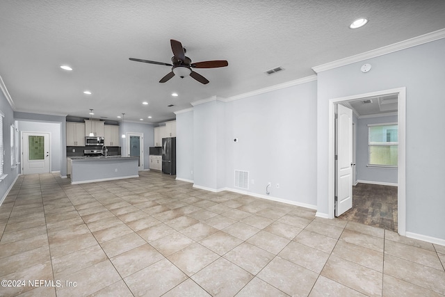 unfurnished living room featuring ceiling fan, crown molding, a textured ceiling, and light tile patterned flooring