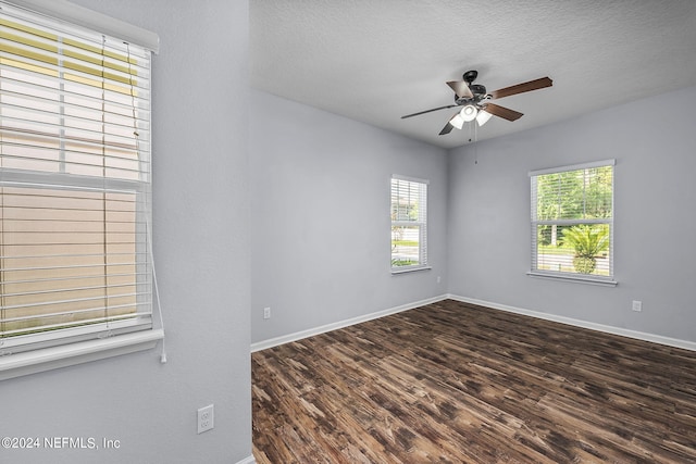 unfurnished room with ceiling fan, dark wood-type flooring, and a textured ceiling