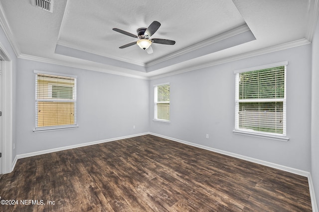 empty room featuring dark wood-type flooring, crown molding, a textured ceiling, a raised ceiling, and ceiling fan