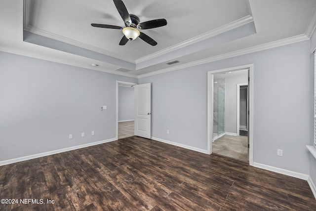 unfurnished room featuring dark wood-type flooring, ceiling fan, ornamental molding, and a raised ceiling