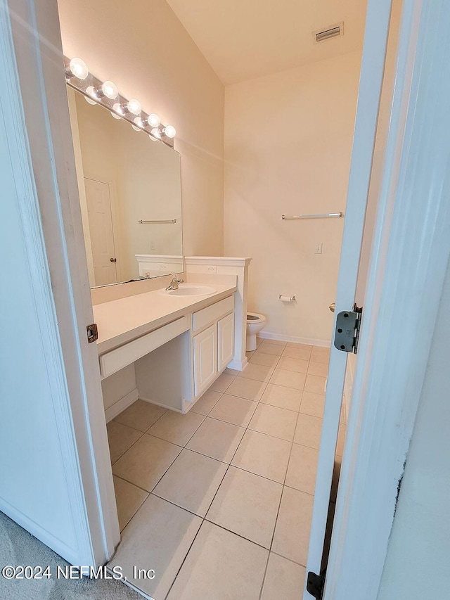 bathroom featuring vanity, tile patterned floors, and toilet