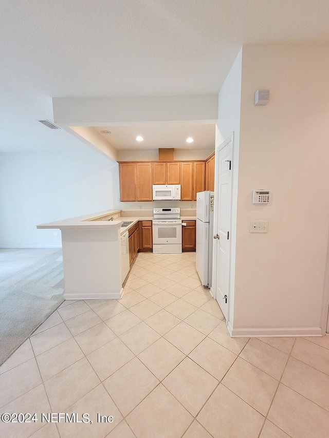 kitchen with white appliances, kitchen peninsula, and light colored carpet