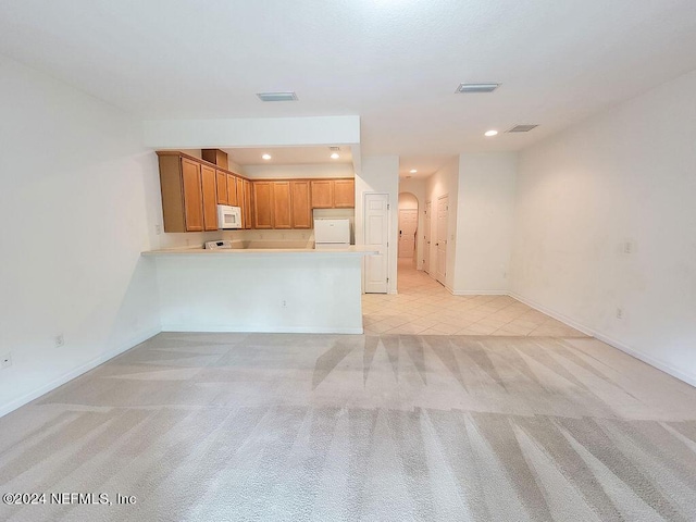 unfurnished living room with light colored carpet