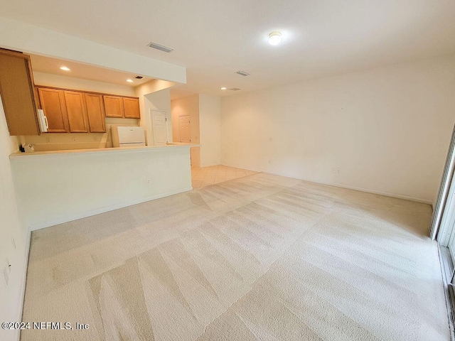 unfurnished living room featuring light carpet