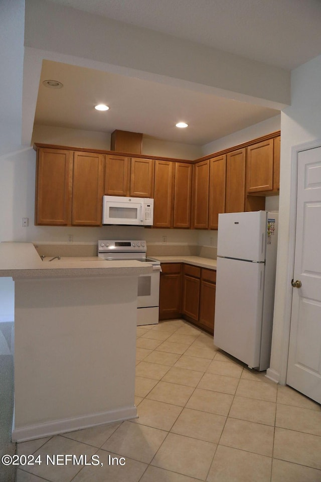 kitchen featuring white appliances, kitchen peninsula, and light tile patterned flooring