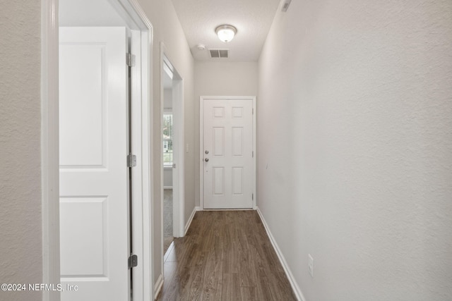 corridor with hardwood / wood-style floors and a textured ceiling