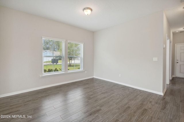 unfurnished room with dark wood-type flooring