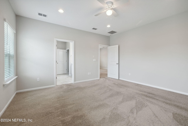 carpeted spare room featuring ceiling fan