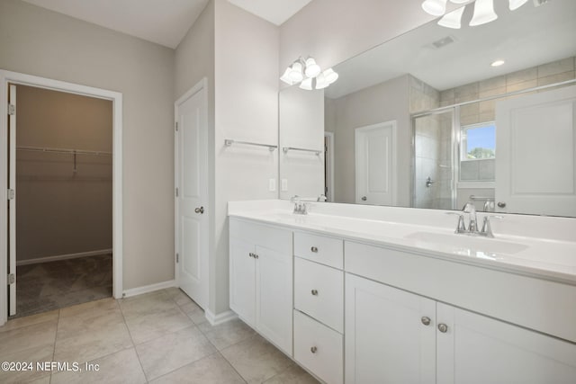 bathroom with tile patterned floors, vanity, and a shower with door