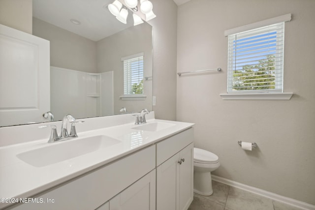 bathroom featuring tile patterned flooring, vanity, toilet, and walk in shower