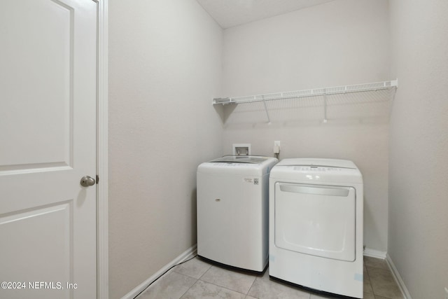 laundry room with washing machine and dryer and light tile patterned floors