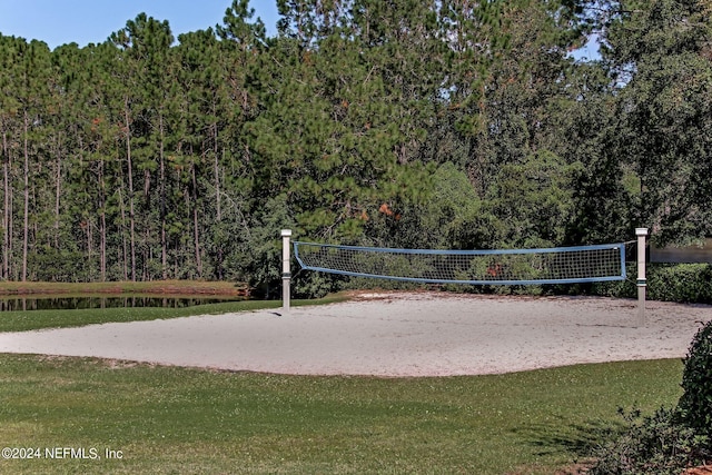 view of home's community featuring a lawn, volleyball court, and a water view