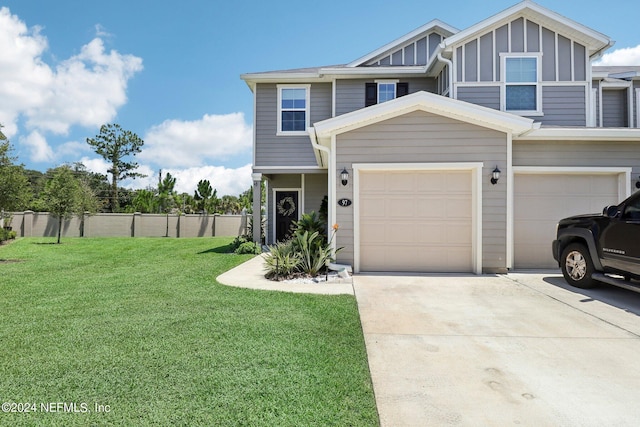 multi unit property featuring a garage and a front lawn