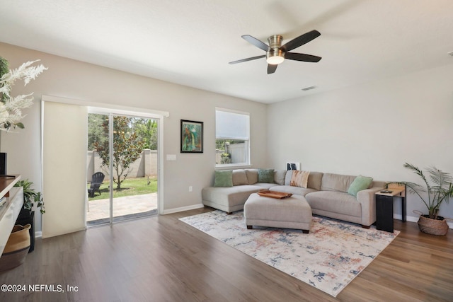 living room with dark wood-type flooring and ceiling fan