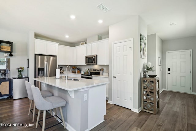 kitchen featuring white cabinetry, stainless steel appliances, sink, and a center island with sink