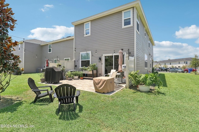 back of house with a patio area and a lawn