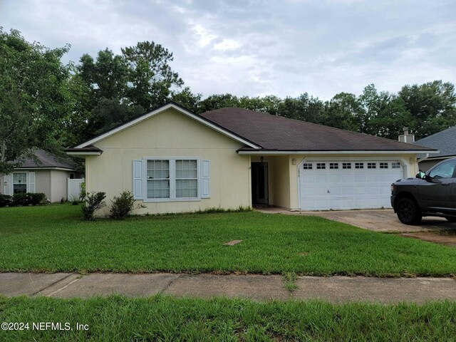 single story home with a garage and a front lawn