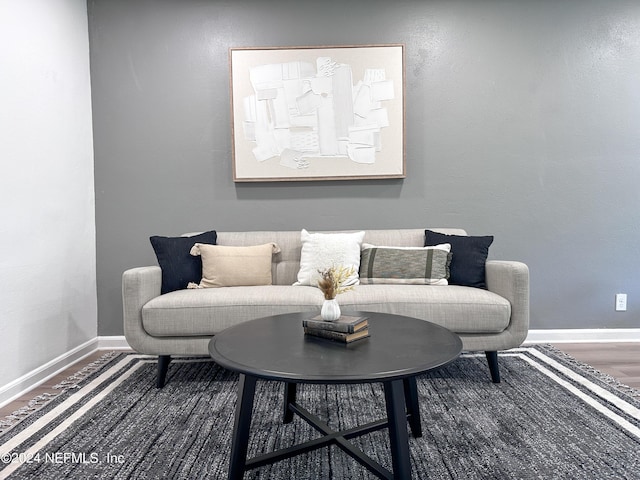 sitting room with baseboards and wood finished floors