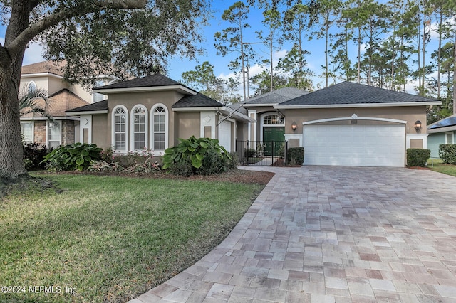 view of front of property featuring a garage and a front lawn