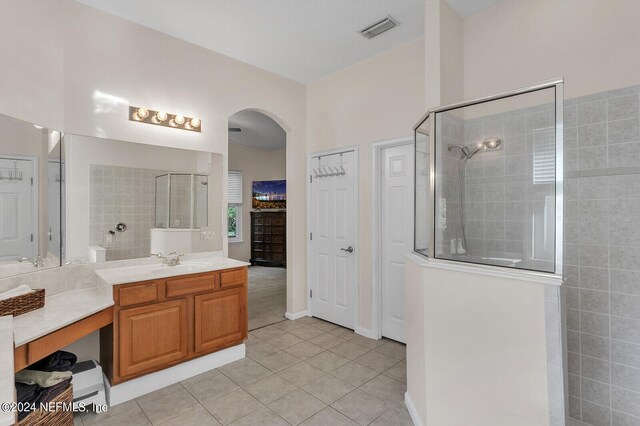 bathroom featuring walk in shower, tile patterned floors, and vanity