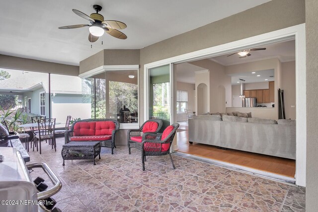 interior space with ornamental molding, plenty of natural light, ceiling fan, and hardwood / wood-style floors