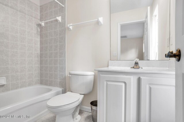 full bathroom with vanity, tile patterned flooring, tiled shower / bath, and toilet