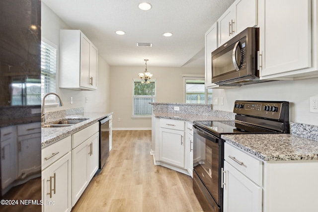 kitchen with decorative light fixtures, appliances with stainless steel finishes, white cabinetry, and sink