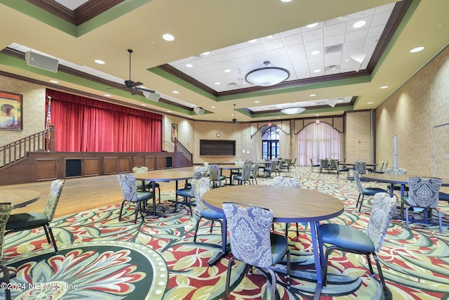 dining space with a tray ceiling, ceiling fan, crown molding, and light hardwood / wood-style floors