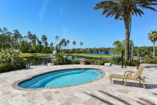 view of swimming pool featuring a patio area, an in ground hot tub, and a water view