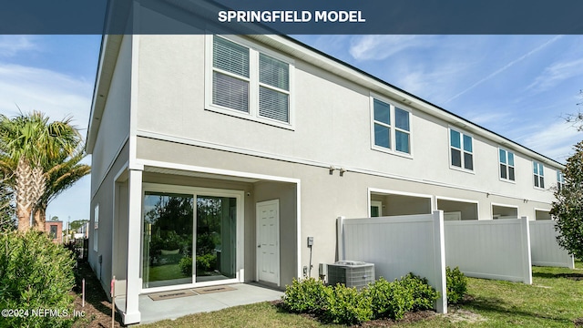 back of property with a lawn and central air condition unit