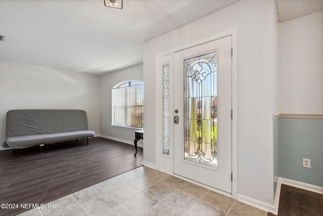 entryway featuring light tile patterned flooring and a textured ceiling