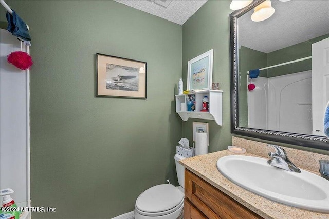 bathroom featuring vanity, a textured ceiling, and toilet