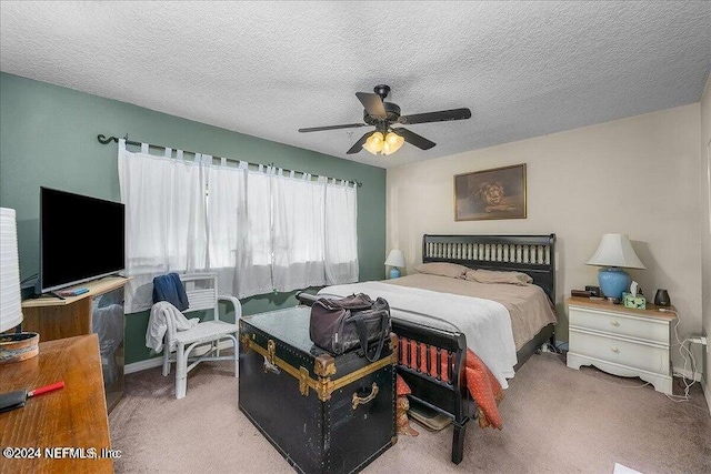 bedroom with a textured ceiling, carpet floors, and ceiling fan