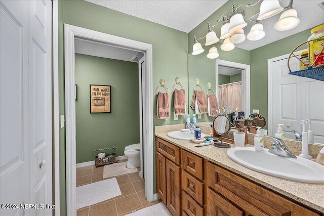 bathroom featuring dual vanity, a textured ceiling, toilet, and tile patterned floors