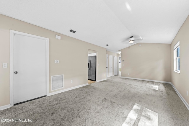 interior space featuring light carpet, ceiling fan, and vaulted ceiling