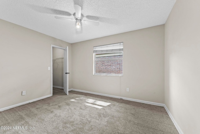 unfurnished bedroom with a textured ceiling, a closet, carpet floors, and ceiling fan