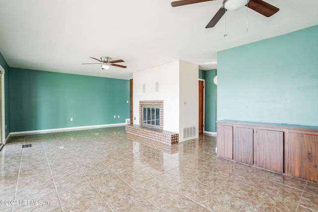 unfurnished living room featuring light tile patterned flooring, a brick fireplace, and ceiling fan