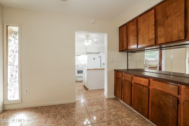 kitchen featuring light tile patterned flooring, ceiling fan, and white appliances