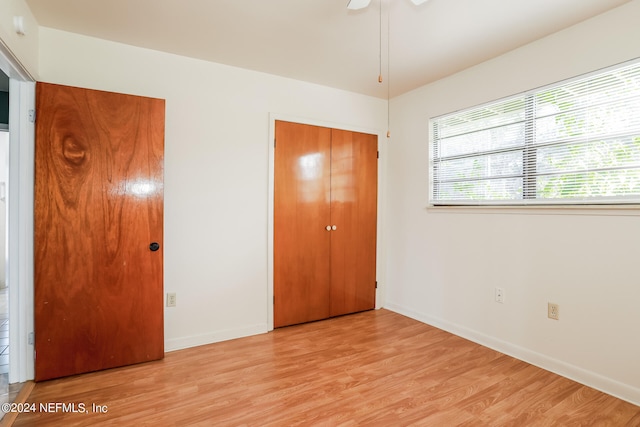 unfurnished bedroom featuring ceiling fan, light hardwood / wood-style flooring, and a closet